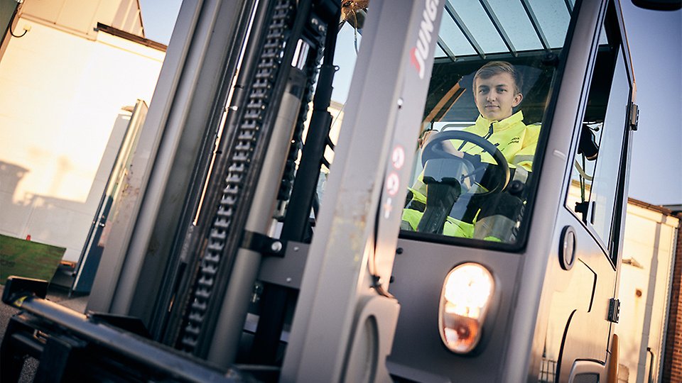 En elev i varselkläder kör en truck
